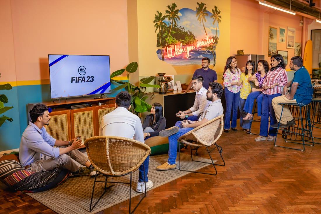 Colleagues gathered around a television playing FIFA in the lounge